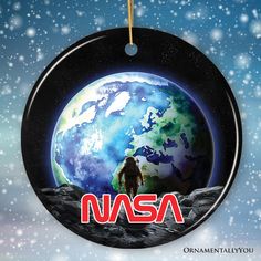 an ornament with the nasa logo hanging from it's side in front of a snowy background