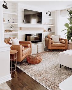 a living room filled with furniture and a flat screen tv mounted on the wall above a fireplace