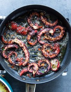 an octopus frying in a skillet on top of a table