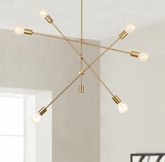 a chandelier hanging from the ceiling in a room with white walls and flooring