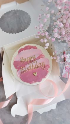 a pink birthday cake sitting on top of a table