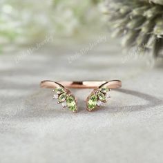 a close up of a ring with two green leaves on the front and one side