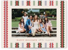 a group of people sitting on top of a wooden bench in front of a christmas card