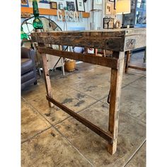 an old wooden table sitting on top of a tile floor