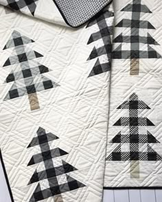 two black and white quilts with trees on them