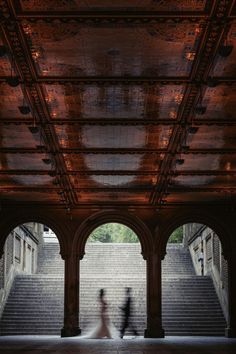 two people walking down some stairs under a bridge