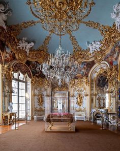 an elaborately decorated room with chandeliers and paintings on the walls in gold