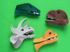 four different types of felt dinosaurs on a green background, one with its mouth open and the other without it's teeth