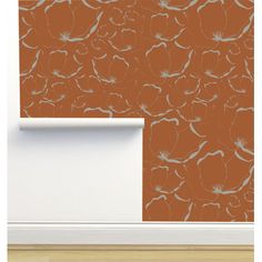 an orange wallpaper with white flowers on it and a window sill in the background