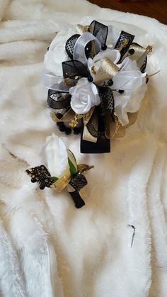 the bridal bouquet is laying on top of a white furnishing blanket with black and gold accents