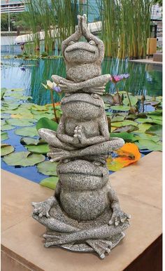 a statue made out of rocks sitting on top of lily pads