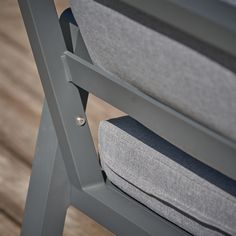 the back end of a gray chair on a wooden floor