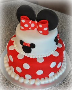 a red and white cake with minnie mouse on top