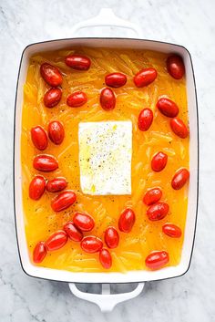 an overhead view of a casserole dish with tomatoes and cheese in the center