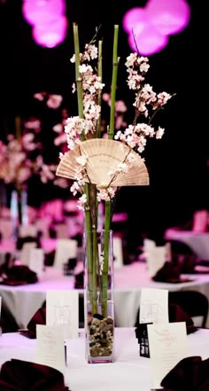 a vase filled with flowers sitting on top of a white table covered in purple lights