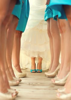 the legs of several bridesmaids in blue and white dresses