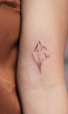 a small flower tattoo on the side of a woman's right arm and thigh