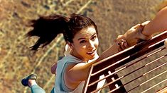 a woman sitting on top of a wooden bench