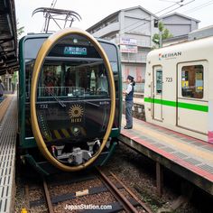 a man standing next to a green and white train