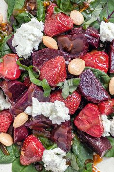 a salad with beets, spinach, feta cheese and almonds on it