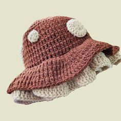 a crocheted hat with white buttons on it