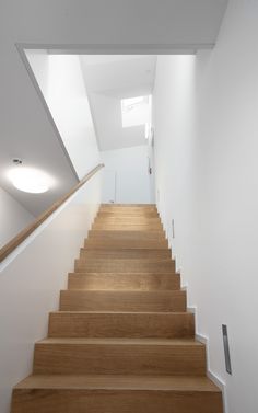 the stairs are made of wood and have white walls