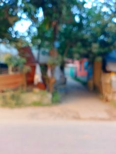 a blurry photo of a red fire hydrant in front of a house and trees