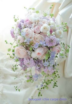 a bridal bouquet with pink and white flowers on the bride's wedding dress