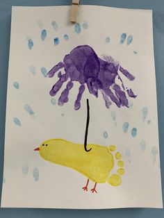 a child's handprint with a yellow duck under an umbrella and purple jellyfish on it