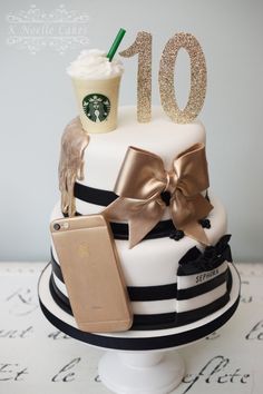 there is a starbucks cake with gold decorations on top and a cup of coffee next to it