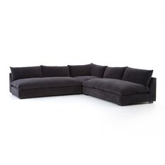 a black sectional couch with pillows on it's back and the seat folded out