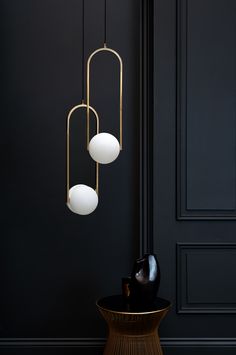 three light fixtures hanging from the ceiling in a room with black walls and flooring