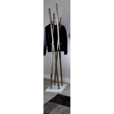 a coat rack with two coats hanging on it's sides and one coat in the middle