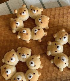 several teddy bears are arranged on a wooden board with googly eyes and nose holes