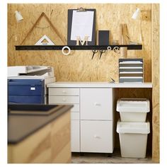 an office area with shelves, filing cabinets and other items on the wall above it