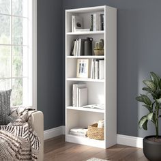 a living room with a white bookcase next to a couch and potted plant