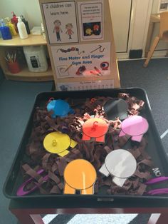 a child's play table filled with different colored paper shapes and scissors on it