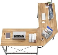 a computer desk with a laptop, keyboard and other items on top of the desk