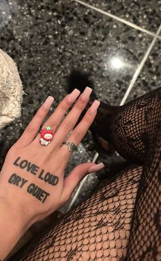 a woman's hand with a tattoo saying love land dry gutt on it