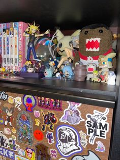 an assortment of stickers and toys on top of a wooden cabinet in a room