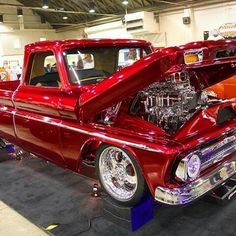 an old red truck is on display at a car show