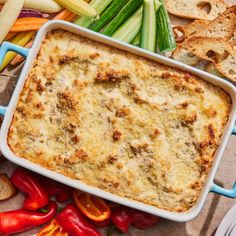 a casserole dish with vegetables and bread on the side, ready to be eaten