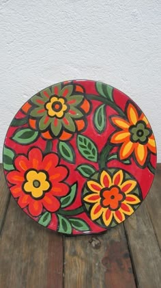 a painted plate sitting on top of a wooden table