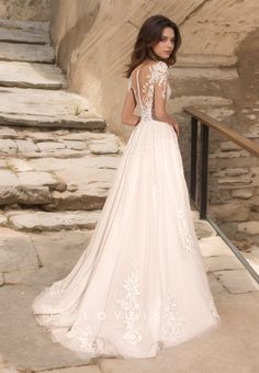 a woman in a wedding dress standing on some steps