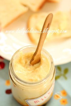 a jar filled with butter sitting on top of a table next to slices of bread