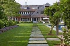 a large house with a pool in the front yard and landscaping on both sides is shown