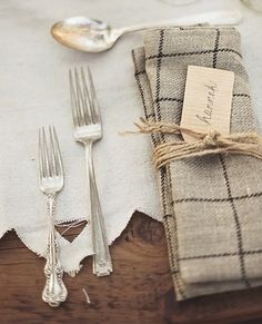 the place setting is set with silverware and napkins