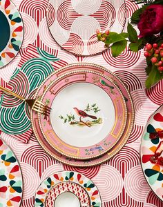 a table topped with colorful plates and flowers