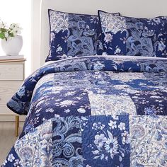 a blue and white quilted bedspread on a bed