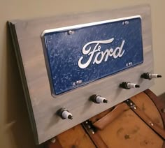 a ford license plate mounted to the side of a wooden barrel car door with rivets and screws on it